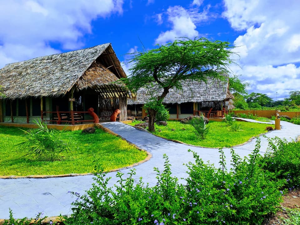 Thatched-roof tented suites with private verandas among the gardens