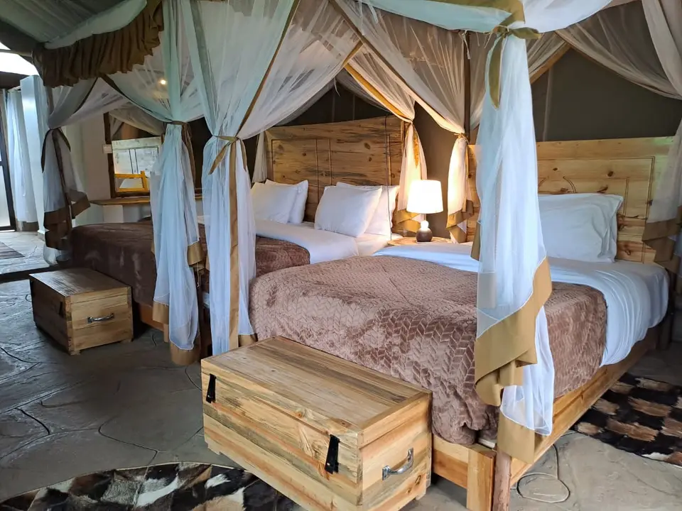 Twin beds beneath mosquito canopies in a tented suite